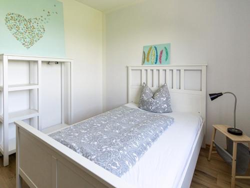 a bedroom with a white bed and a lamp at Ferienwohnung Landurlaub in Bad Feilnbach