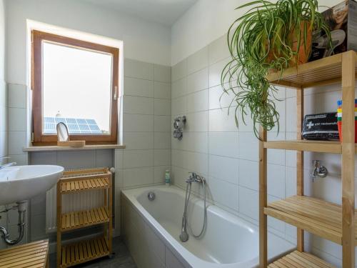 a bathroom with a bath tub and a sink at Ferienwohnung Landurlaub in Bad Feilnbach