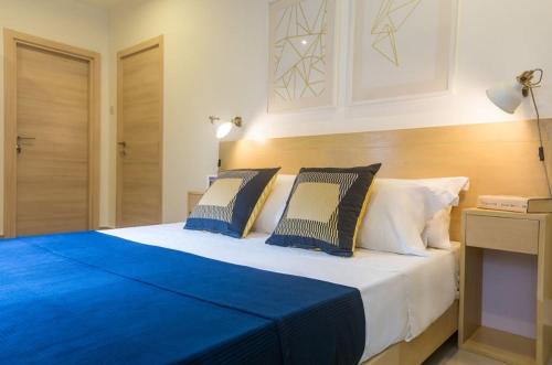 a bedroom with a large bed with blue sheets and pillows at The Gallery Luxury Apartments in Accra
