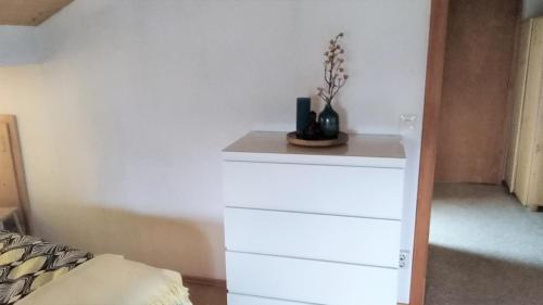 a white dresser in a room with a bed at Ferienwohnung Landurlaub in Bad Feilnbach