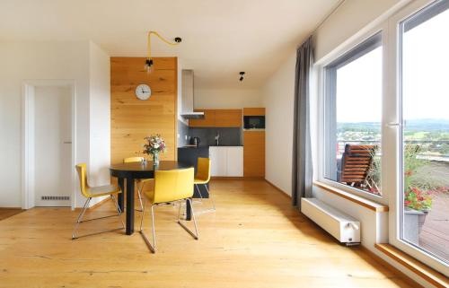 a dining room and kitchen with a table and yellow chairs at Mountain Apartment Vrchlabi in Vrchlabí