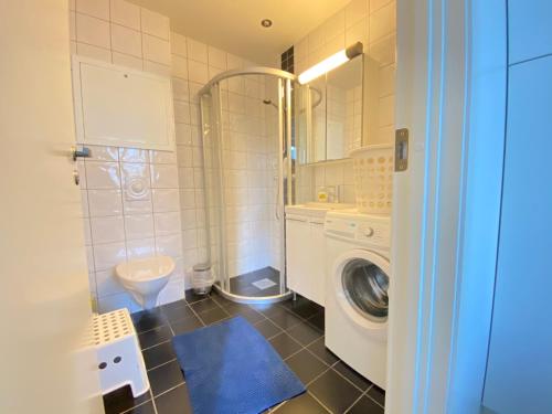 a bathroom with a washing machine and a washer at The beautiful Verven 2A in Stavanger