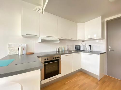 a kitchen with white cabinets and stainless steel appliances at The beautiful Verven 2A in Stavanger