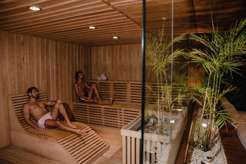 a man and a woman sitting in a sauna at The Reef 28 Hotel & Spa - Luxury Adults Only - All Suites - With Optional All Inclusive in Playa del Carmen