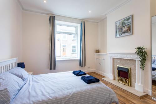een slaapkamer met een bed en een open haard bij FREE PARKING -2 Bed Apartment, 7mins to City Centre - by StirkMartin in Cardiff