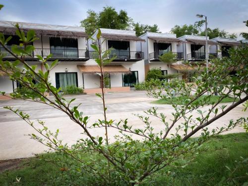 a row of apartment buildings with a courtyard at Suwi Coco Ville Resort in Ubon Ratchathani