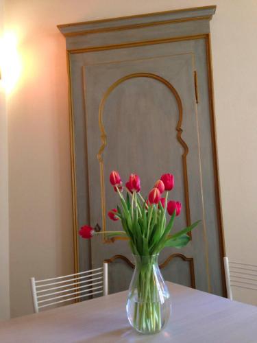 a vase of red tulips sitting on a table at La Casa Di Cocca in Alba