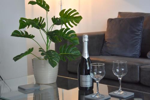 a bottle of wine and two glasses on a table at Friarscroft Lodge Holiday Home in Wymondham