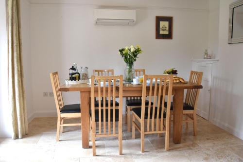Friarscroft Lodge Holiday Home في ويموندهام: طاولة طعام مع كراسي وطاولة خشبية