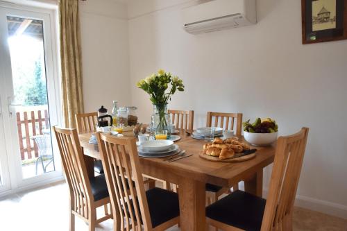 a wooden table with a bowl of food on it at Friarscroft Lodge Holiday Home in Wymondham