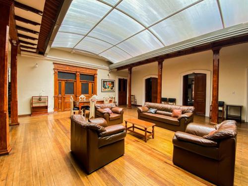 a living room with leather furniture and a glass ceiling at Casona Hotel in Pasto