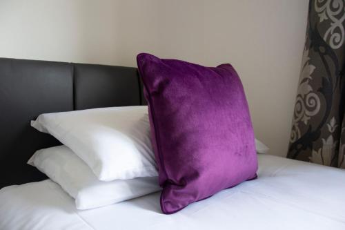 a purple pillow sitting on top of a bed at Friarscroft Lodge Holiday Home in Wymondham