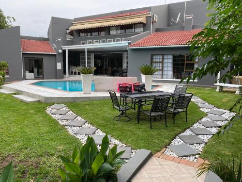 a patio with a table and chairs next to a house at Marion Lodge in Johannesburg