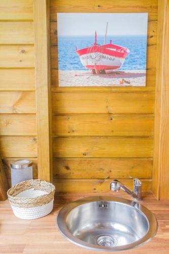 a bathroom with a sink and a picture of a boat at Carre Royal in Deshaies