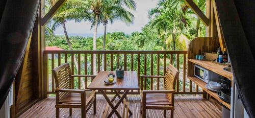 a porch with a table and chairs on a balcony at Carre Royal in Deshaies