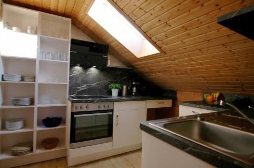 a kitchen with a sink and a stove at Ferienhaus Ahorn in Mittelberg