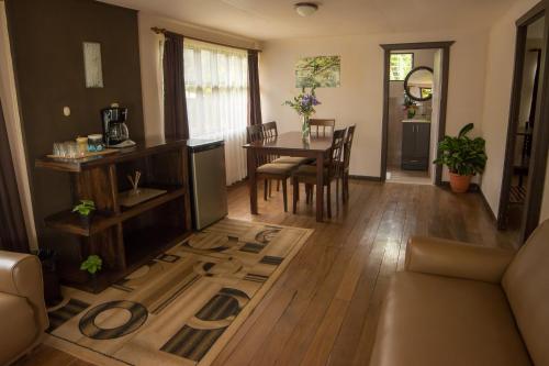 a living room with a table and a dining room at Cabinas El Quetzal in San Gerardo de Dota