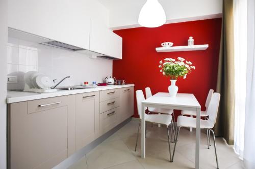 a kitchen with a white table and a red wall at Finestre d'Occidente in Trapani