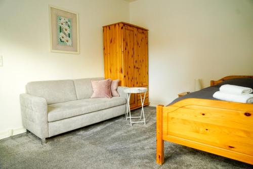 ein Schlafzimmer mit einem Sofa, einem Bett und einem Stuhl in der Unterkunft Ferienhaus nahe Uni Lueneburg in Lüneburg