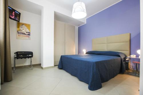 a blue bedroom with a bed and a chair at Finestre d'Occidente in Trapani