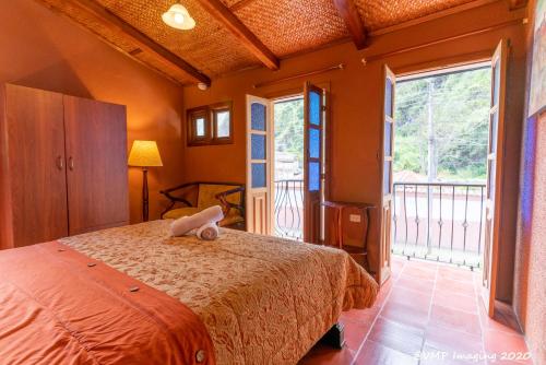 a bedroom with a bed and a large window at La Posada Del Arte in Baños