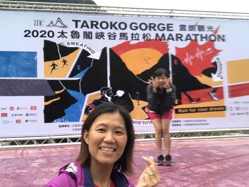 a woman taking a picture in front of a poster at 太魯閣惠宇民宿 in Xincheng