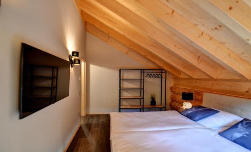 a bedroom with a bed and a wooden ceiling at Ferienblockhäuser der Familie Lakmann in Feldberg