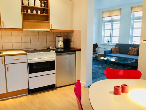 a kitchen and living room with a table and a couch at City Hotel Apartments in Odense