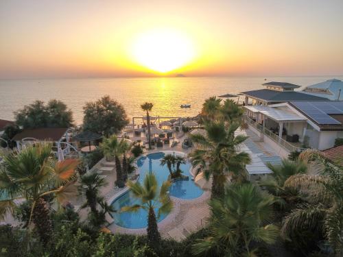 カーポ・ヴァチカーノにあるBaia del Godano Resort & Spaのプールと海を望むリゾートの空からの景色を望めます。