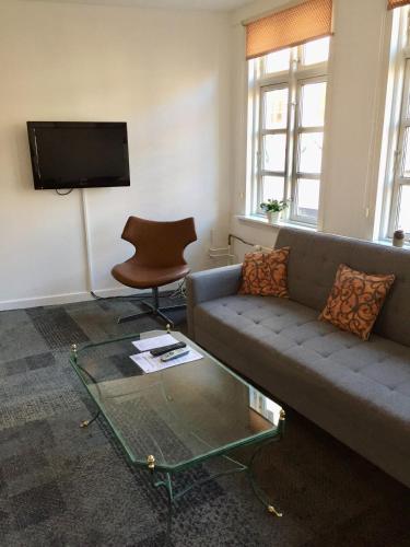 a living room with a couch and a glass table at City Hotel Apartments in Odense