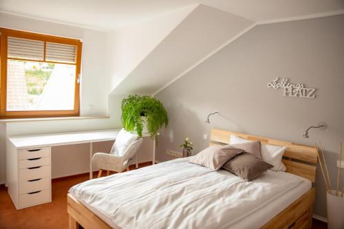 a bedroom with a bed and a desk at Hotel Wappenstube in Erbach im Odenwald