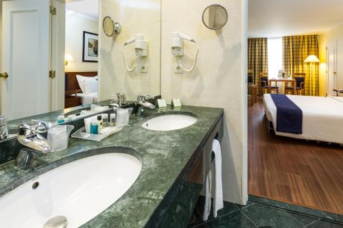 
a bathroom with two sinks and a large mirror at Holiday Inn Lisbon, an IHG Hotel in Lisbon
