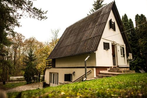 a small white house with a black roof at Fenyves út 1 in Esztergom