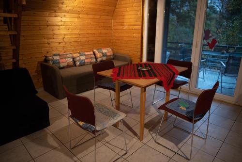 - un salon avec une table, des chaises et un canapé dans l'établissement Fenyves út 1, à Esztergom