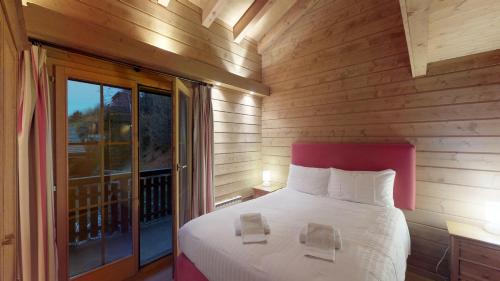 - une chambre avec un grand lit et un balcon dans l'établissement Natasha EXCEPTIONAL & LUXE chalet 12 pers by Alpvision Résidences, à Nendaz