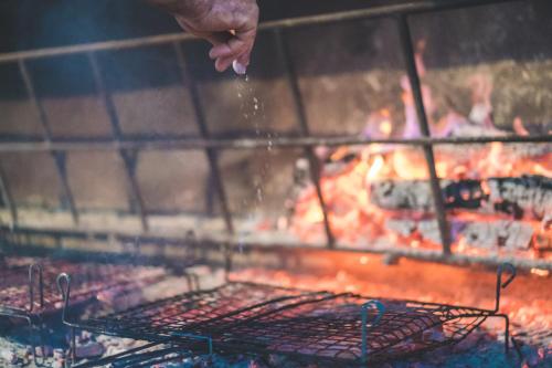 a person is cooking food on a grill at Fattoria Didattica La Collina Incantata in Narni