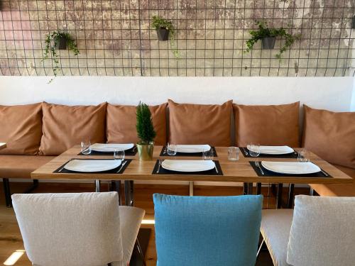 einen Tisch in einem Restaurant mit Stühlen, Tellern und Gläsern in der Unterkunft Fatty George in Wien