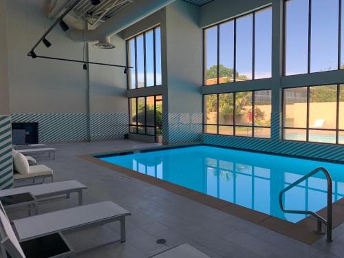 a large swimming pool in a building with windows at Holiday Inn Baton Rouge-South by IHG in Baton Rouge