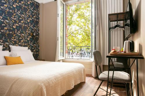 Schlafzimmer mit einem Bett und einem Fenster in der Unterkunft Le Grand Albert 1er in Maisons-Alfort