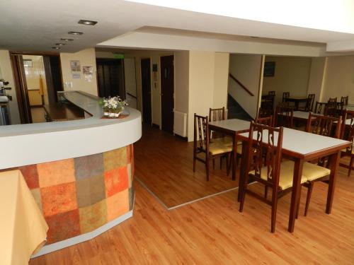 a restaurant with a counter and tables and chairs at Gran Hotel Monaco in Mar del Plata