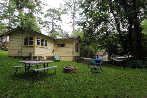 a house with a picnic table and a hammock in the yard at The Pines Cottages in Asheville