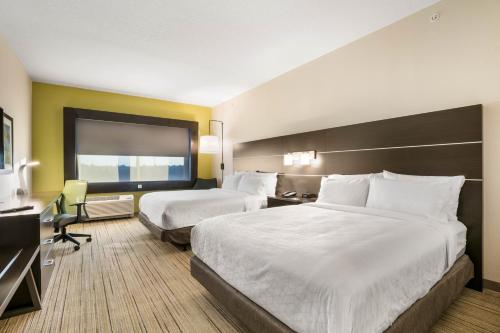 ジャクソンビルにあるHoliday Inn Express & Suites Jacksonville - Town Center, an IHG Hotelのベッド2台とデスクが備わるホテルルームです。