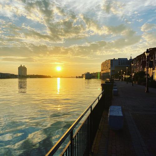 a sunset over a body of water with the sun setting at Savannah Inn and Suites Savannah Port Area in Savannah