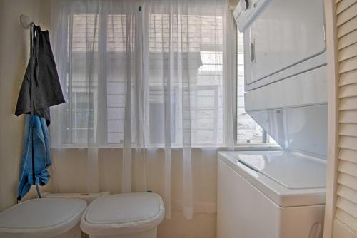 a white bathroom with a toilet and a window at Avalon Escape Everything Within Walking Distance! in Avalon