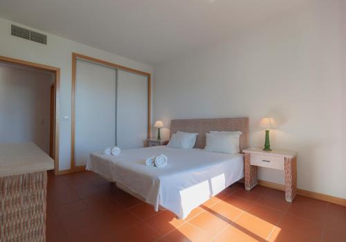 Un dormitorio con una gran cama blanca y una ventana en Residence Golf Club by Garvetur, en Vilamoura