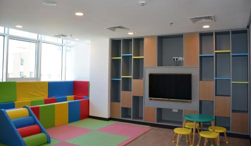 a room with colorful furniture and a tv at The Lodge Suites in Manama