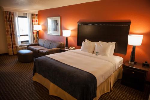 um quarto de hotel com uma cama grande e uma cadeira em Decatur Conference Center and Hotel em Decatur