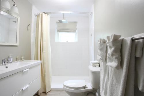 a white bathroom with a toilet and a sink at The Pines Cottages in Asheville