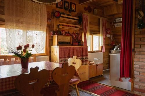 a kitchen with a dining table and a kitchen with a refrigerator at Ethno Cottage "Biljana" in Zlatibor