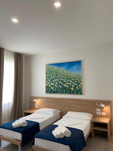 a hotel room with two beds and a painting on the wall at Locanda Damaro in Vicenza